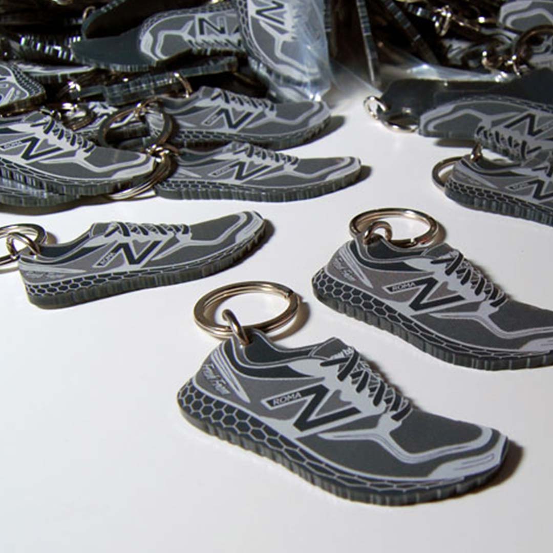 Portachiavi in plexiglass grigio forma scarpette New Balance per promozione durante maratona di Roma