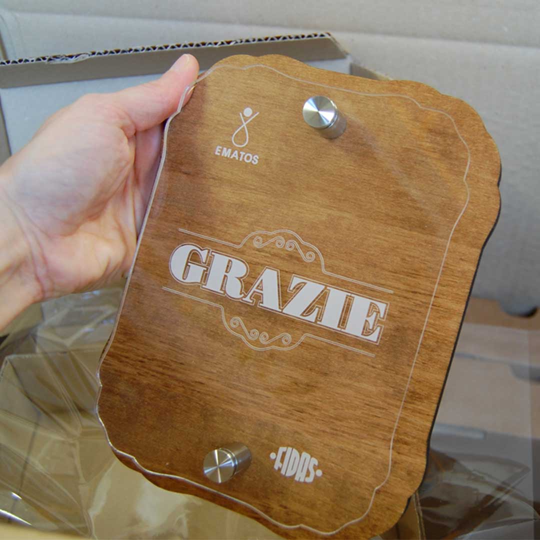 Targa in legno con distanziali inox e strato di plexiglass trasparente con scritta GRAZIE incisa insieme ai loghi donatori sangue.